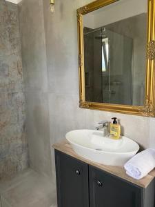 La salle de bains est pourvue d'un lavabo blanc et d'un miroir. dans l'établissement Holiday house Ana, à Skradin