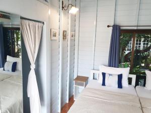 2 Betten in einem Schlafzimmer mit blauen und weißen Kissen in der Unterkunft KINN Stay50 Bangkok in Bangkok Yai