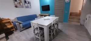 Una sala de estar con una mesa y un sofá azul. en Casa Mael, en Villasimius