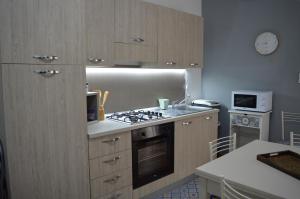 a kitchen with wooden cabinets and a stove top oven at Casa vacanza Nicuzza in Castellammare del Golfo