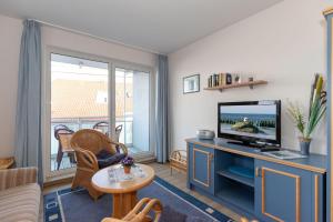 a living room with a tv and a couch at Yachthafenresidenz-Wohnung-8307-862 in Kühlungsborn