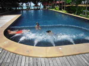 a group of people swimming in a swimming pool at Palita Lodge - SHA Plus in Haad Rin