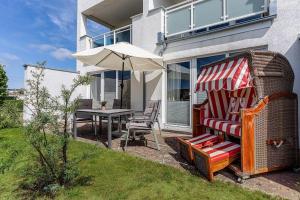 a patio with a table and an umbrella and a table and chairs at Yachthafenresidenz-Wohnung-9101-877 in Kühlungsborn