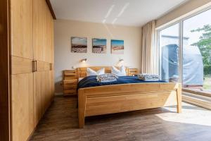 a bedroom with a bed and a large window at Yachthafenresidenz-Wohnung-9101-877 in Kühlungsborn