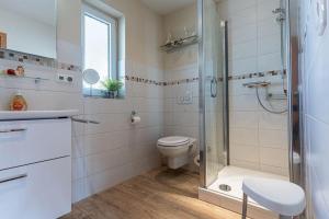 a bathroom with a toilet and a glass shower at Yachthafenresidenz-Wohnung-9101-877 in Kühlungsborn