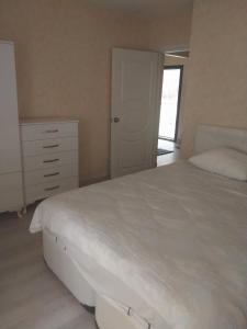 a bedroom with a large white bed and a dresser at Village Garden Pansiyon in Cıralı
