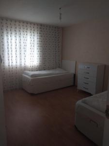 a small bedroom with a bed and a dresser at Village Garden Pansiyon in Cıralı