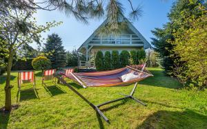 a hammock in a yard in front of a house at ATMA Domki in Bobolin
