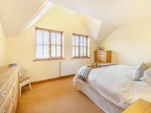 a bedroom with a bed and a dresser and windows at Pennant in Llangurig