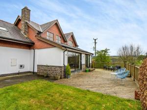 a house with a patio with a table and chairs at Pennant in Llangurig