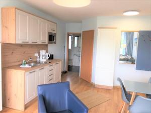 a kitchen with a sink and a table with chairs at Yachthafenresidenz-Wohnung-9106-881 in Kühlungsborn