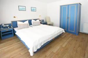 キュールングスボルンにあるYachthafenresidenz-Wohnung-9109-883のベッドルーム1室(大型ベッド1台、青いキャビネット付)