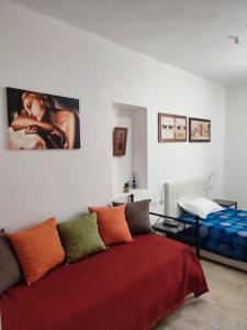 1 dormitorio con 1 cama con manta roja en Archubintu B&B your friendly place en Sassari