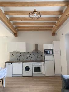 een keuken met witte apparatuur en een houten plafond bij APARTAMENTO EN LEKEITIO in Lekeitio