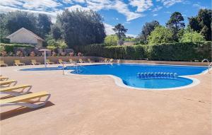 a swimming pool with lounge chairs next to at Stunning stacaravan In Saint-georges-de-didon With Heated Swimming Pool in Saint-Georges-de-Didonne
