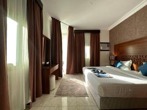 a hotel room with a bed and a large window at ترند سويتس - TREND Suites in Al Baha