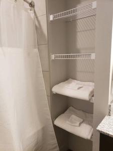 uma casa de banho com chuveiro e toalhas brancas em Monument Resort like amenities with King bd Qn bd Garage Fast WiFi Sleeps em Monument