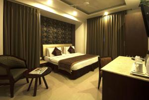 une chambre d'hôtel avec un lit et une chaise dans l'établissement Hotel Le Roi Near New Delhi Railway Station, à New Delhi