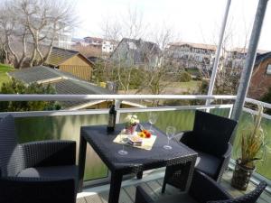 einen Tisch und Stühle auf einem Balkon mit Weingläsern in der Unterkunft Yachthafenresidenz - Wohnung 7204 / 915 in Kühlungsborn