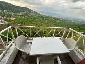 een witte tafel en stoelen op een balkon met uitzicht bij City View Condominium in Skopje