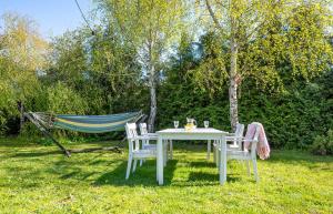 a table and chairs in a yard with a hammock at ATMA Domki in Bobolin