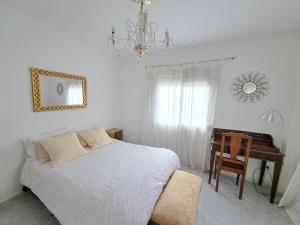 a bedroom with a bed and a desk and a chandelier at Apartamento acogedor con wifi in Valencia