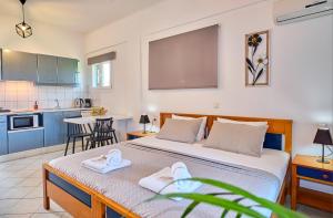 - une chambre avec un grand lit et des serviettes dans l'établissement Logas Beach Studios Peroulades Corfu, à Peroulades