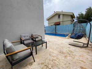un patio con 2 sillas y un columpio en Flat with Shared Pool and Garden in Kalkan Antalya, en Kalkan