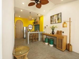 a kitchen with yellow walls and a ceiling at TA Danang Boutique Hotel in Da Nang