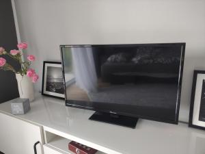 una TV a schermo piatto seduta sopra un tavolo di Apartment Talarowa Delux a Varsavia