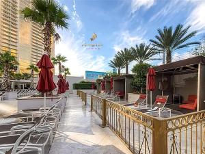 a patio with chairs and umbrellas on a balcony at Amalz Deluxe Suites at Mgm Signature ! in Las Vegas