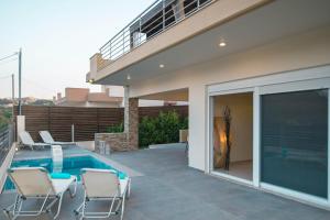een patio met een zwembad en stoelen naast een huis bij MeFoMi Villa in Rhodos-stad