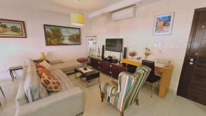 een woonkamer met een bank en een bureau met een televisie bij STAY Serenity Apartment in Yukarı Lakatamya