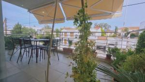 een patio met een tafel en stoelen op een balkon bij STAY Serenity Apartment in Yukarı Lakatamya