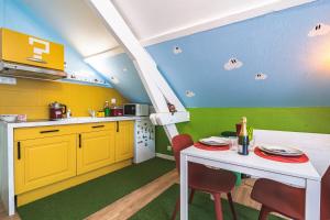 une cuisine avec des armoires jaunes, une table et des chaises dans l'établissement ExploreReims - studio magique proche gare et centre, à Reims