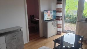 uma sala de estar com uma televisão e uma mesa em EXCLUSIVES TOP-Apartment in traumhafter Aussichtslage WLAN kostenfrei em Schöfweg
