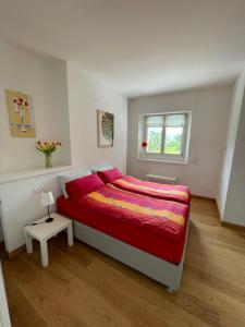 sypialnia z czerwonym łóżkiem i oknem w obiekcie Appartamento Riviera w mieście Cremia