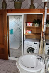 a bathroom with a washing machine and a shower at Casa do Museu Marítimo in Santo Amaro