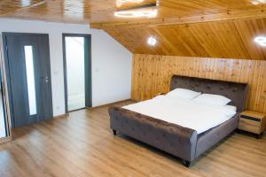 Bett in einem Zimmer mit Holzdecke in der Unterkunft EDA ROOMS in Sibiu