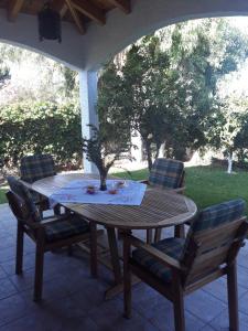 a wooden table and chairs on a patio at Villa Anesis-Παραθαλάσσια βίλα in Amaliás