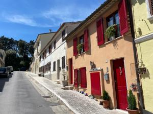 una calle con persianas rojas en un edificio en Appartamento incantevole sull'antica via Lauretana en Loreto