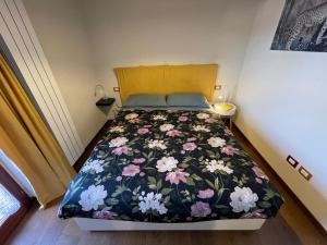 a bedroom with a bed with a floral bedspread at Appartamento incantevole sull'antica via Lauretana in Loreto