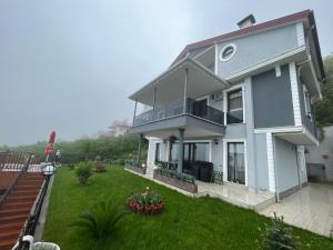 a large white house with a yard with plants at Villa Nature in Trabzon