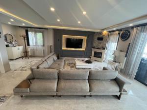 uma grande sala de estar com um sofá e uma televisão em Villa Nature em Trabzon