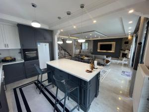 a kitchen with black cabinets and a kitchen island with chairs at Villa Nature in Trabzon