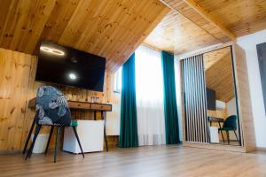 Habitación con escritorio, TV y silla. en EDA ROOMS, en Sibiu
