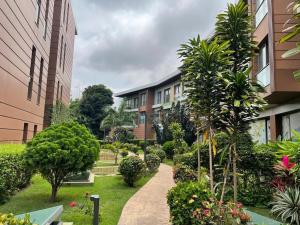 een tuin met planten, bomen en gebouwen bij Silver-bell Apartments in Accra