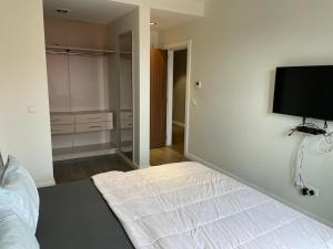 een slaapkamer met een bed en een flatscreen-tv bij Silver-bell Apartments in Accra