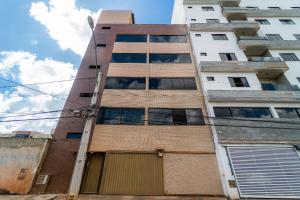 ein hohes Gebäude mit einer Garage davor in der Unterkunft Apartamentos Com Suite ,Wi-Fi 500MB , Estacionamento, Elevador, Cozinha Completa , Jr Catito in Brasilia