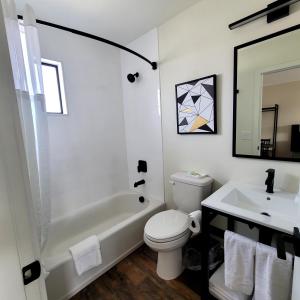 a bathroom with a white tub and a toilet and a sink at Richland Inn and Suites in Richland